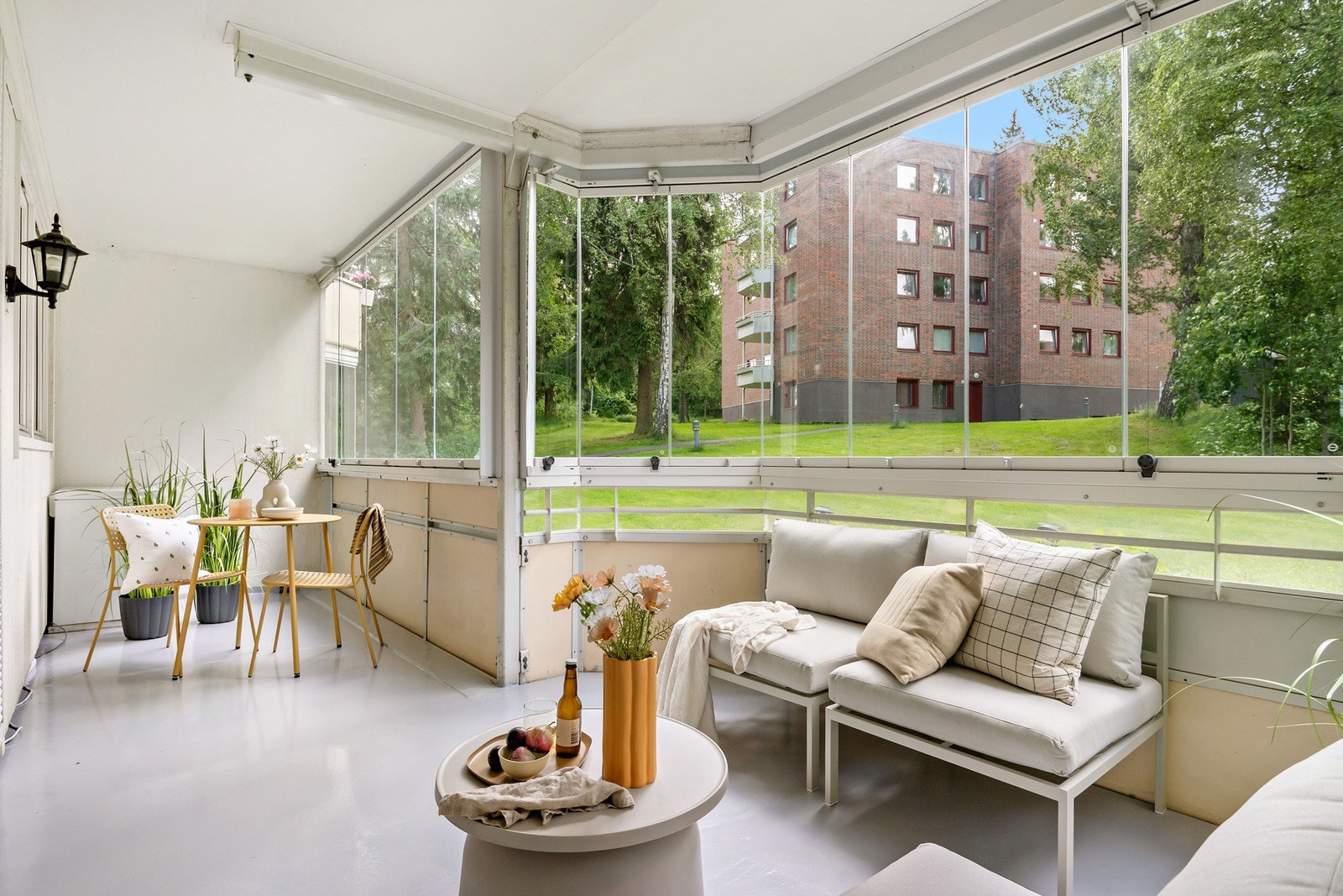 Romslig innglasset balkong med god utsikt mot grøntområdet og nabolaget - her er det plass til både lounge og spiseplass. Galleribilde