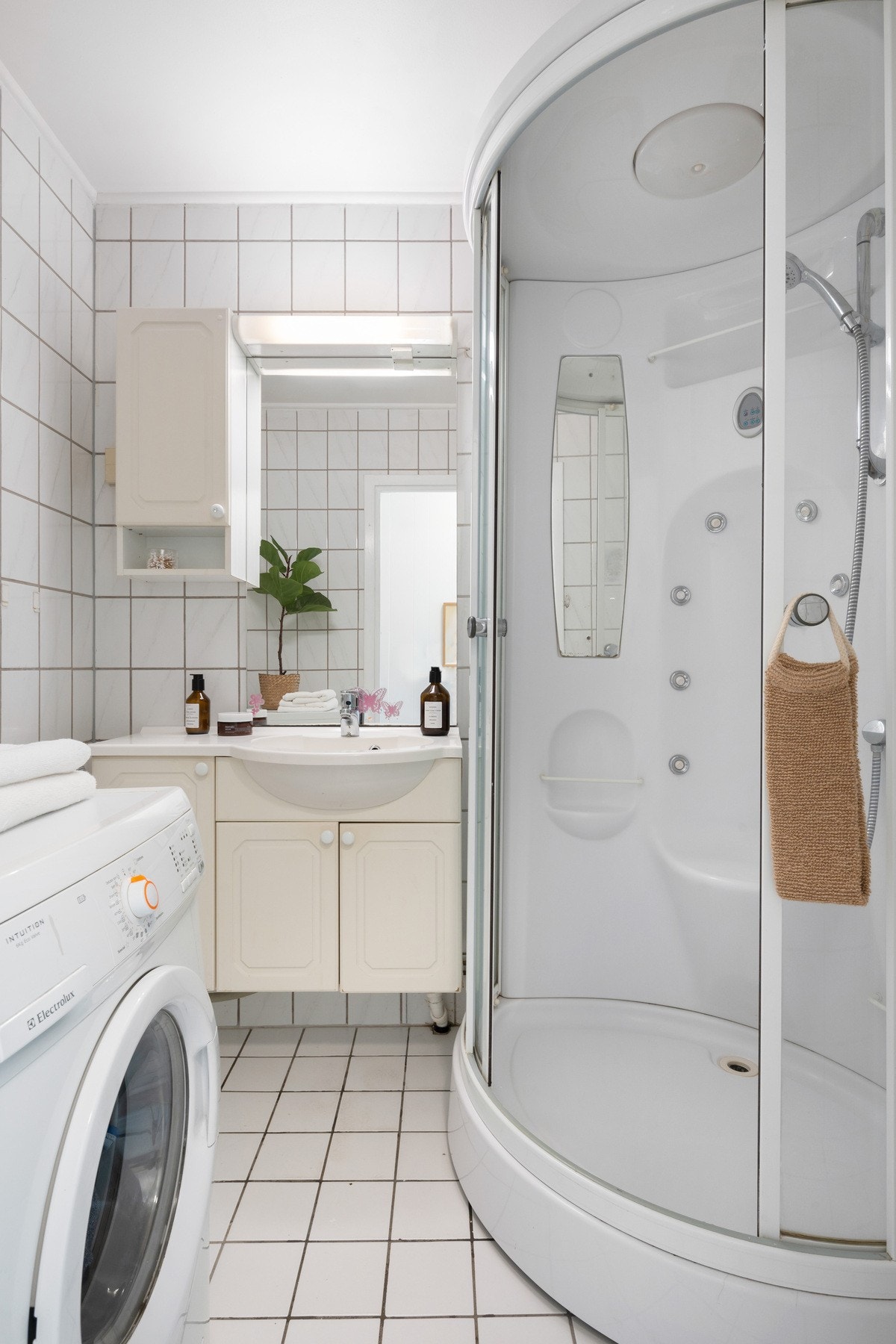 Badet er innredet med dusjkabinett, servant med innredning og opplegg for vaskemaskin. Galleribilde