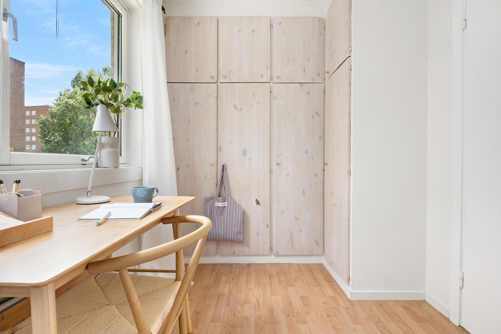 Innbydende soverom med garderobeskap langs veggen og naturlig lysinnslipp fra stort vindu. Galleribilde