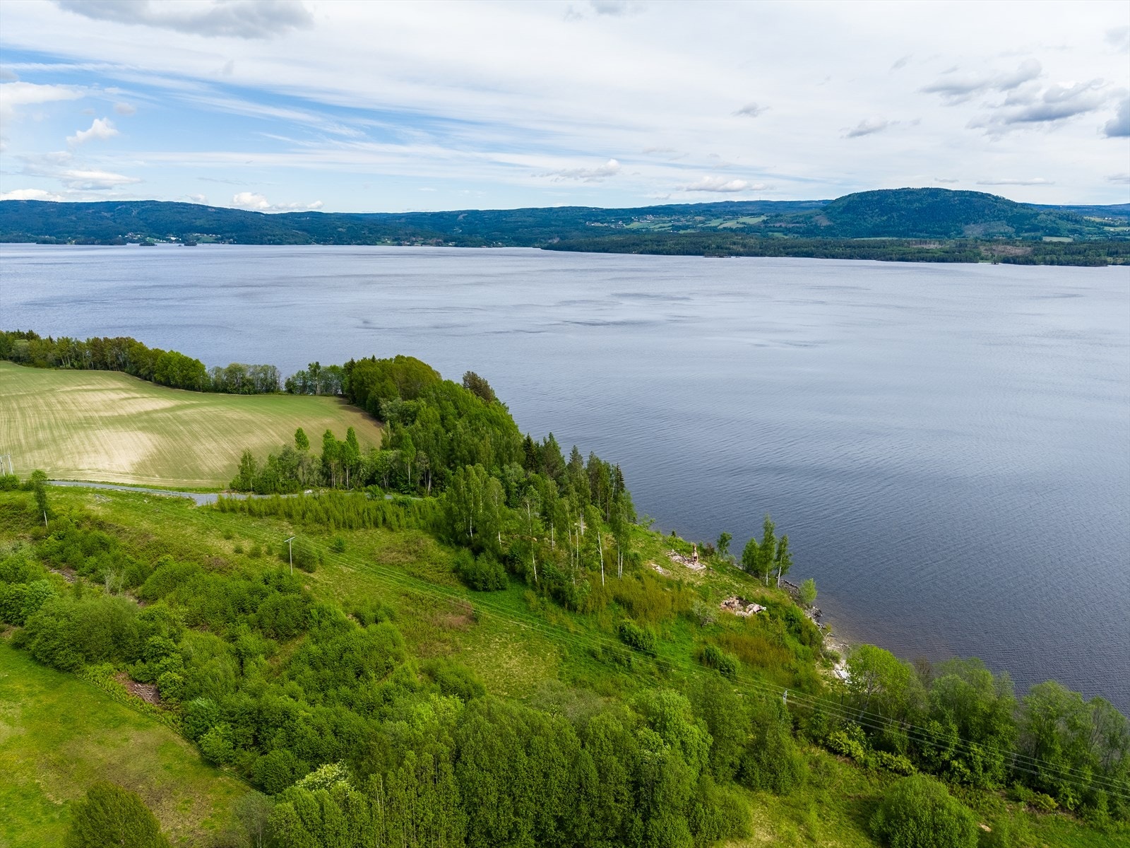 Fra et fremtidig bolighus vil du ha utsikt over speilblank fjord og videre over mot Nes kirke, Røykenvik og Brandbukampen som ligger på motsatt side. Galleribilde