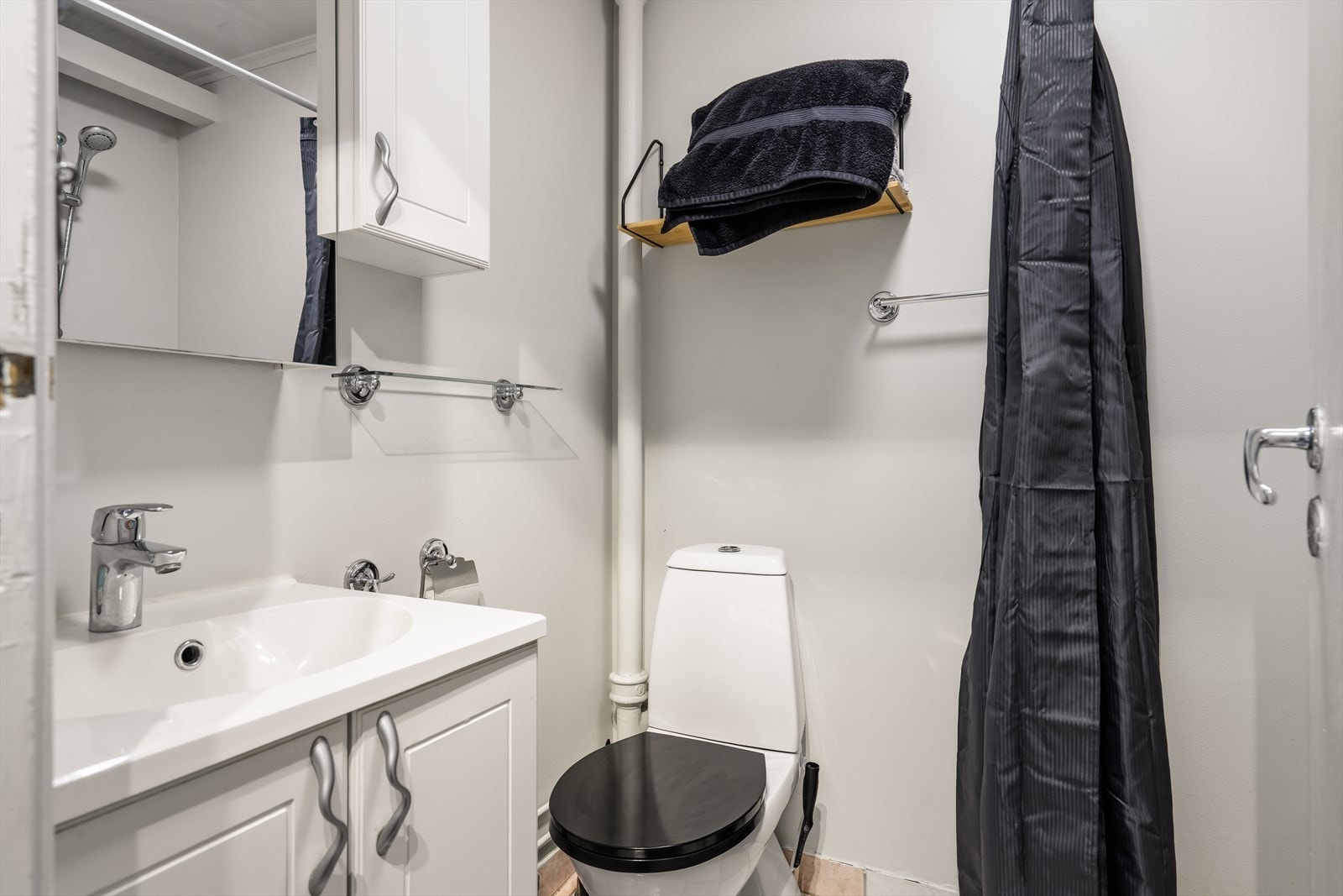 Badet er innredet med toalett, servant med underskap og et praktisk dusjhjørne. Galleribilde