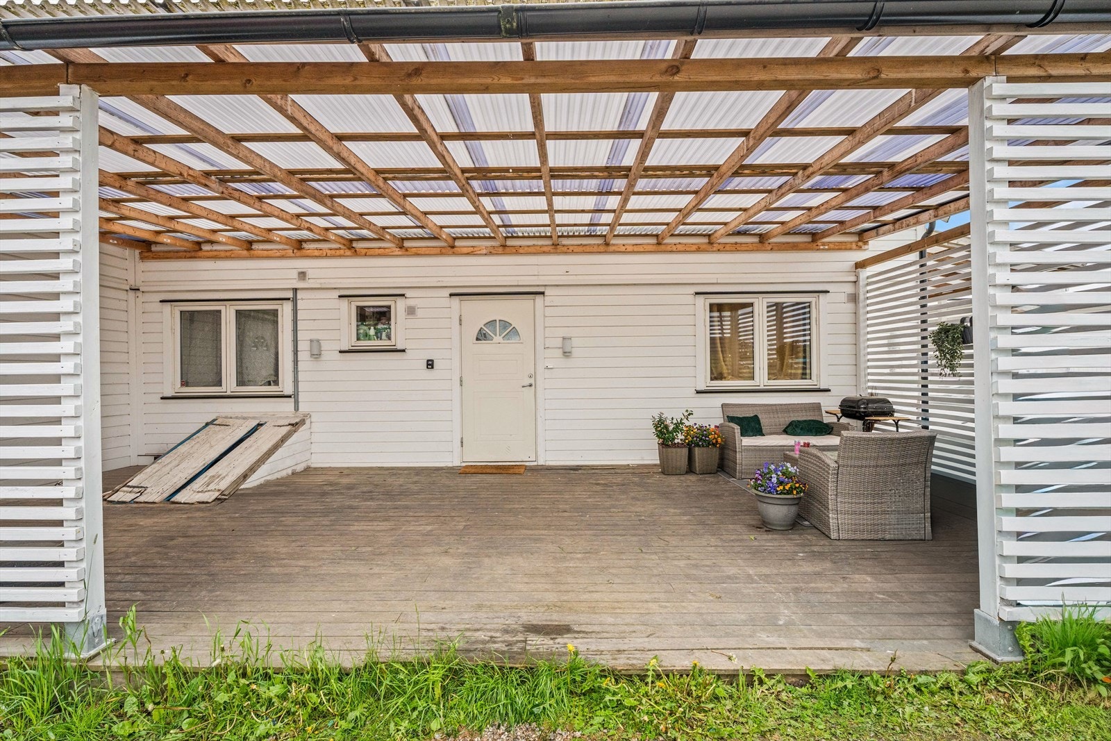 Den felles, overbygde inngangsterrassen på ca. 57 m² gir et skjermet og sosialt uterom for beboerne. Galleribilde
