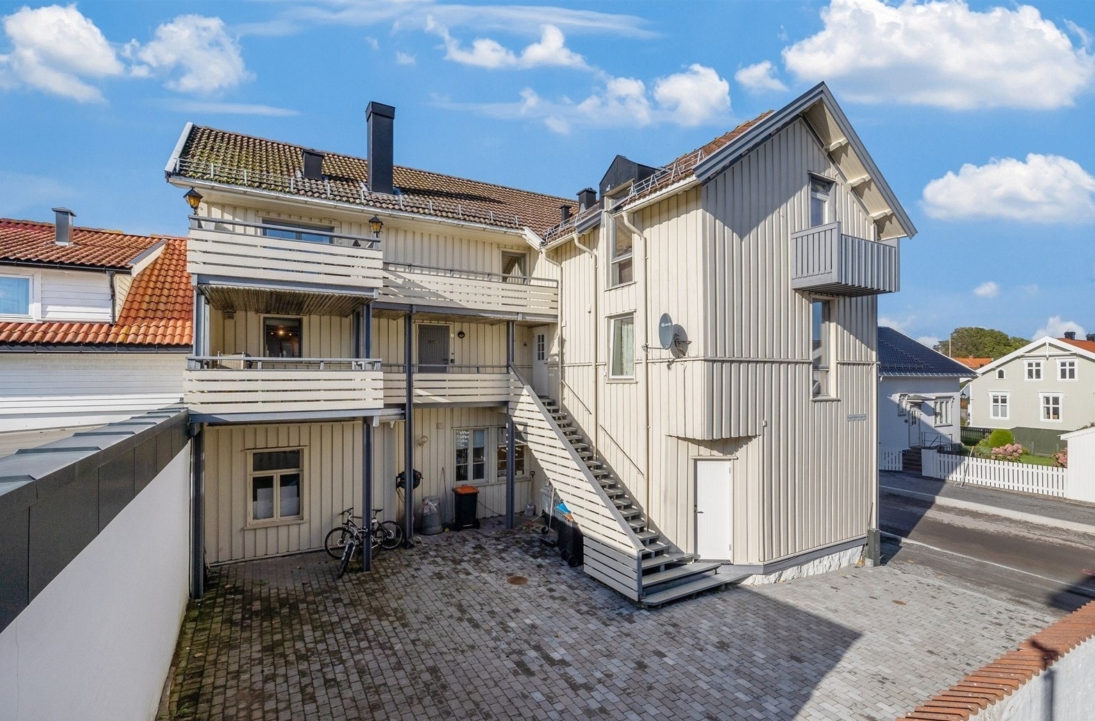 Byggets bakside med felles gårdsrom og adkomst. Bod i fellesrom. Galleribilde