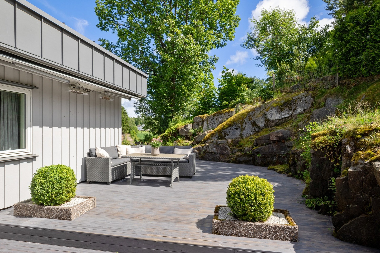 Stor terrasse med flere soner for utemøbler, grill og sosiale sammenkomster. Galleribilde