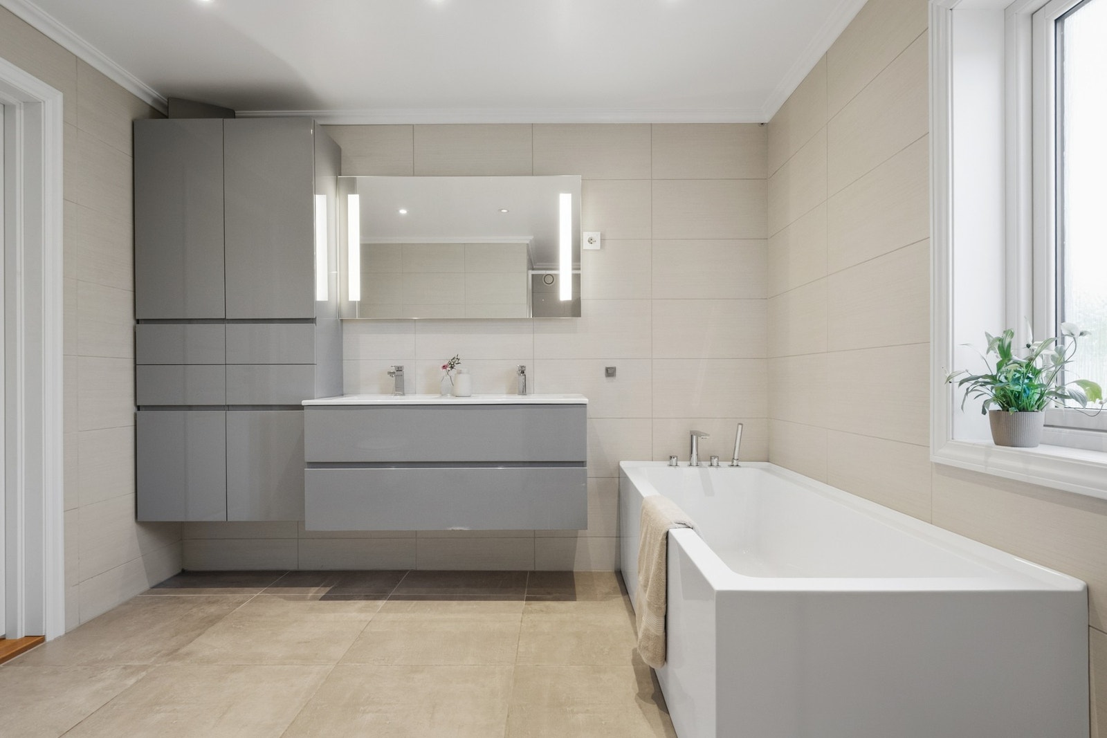 Flislagt bad fra 2013 med varmekabler i gulv. Badet er innredet med servantinnredning, toalett, badekar og dusjnisje. Galleribilde