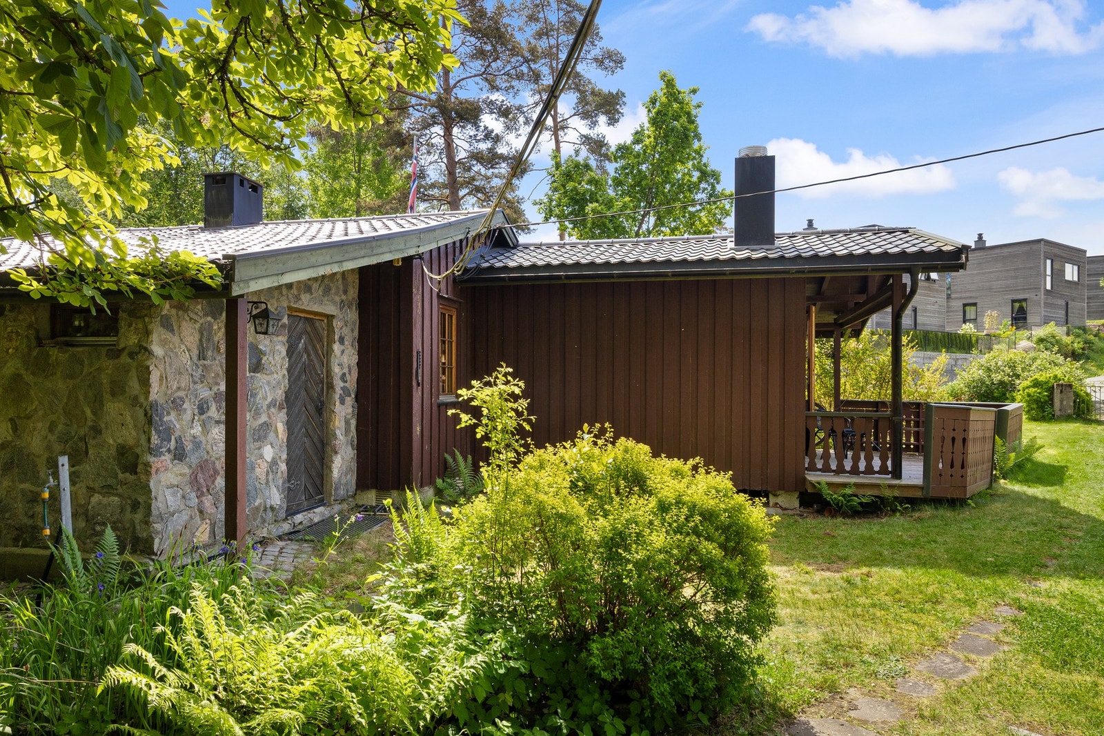 Hytten har et sjarmerende eksteriør med kombinasjon av treverk og naturstein Galleribilde