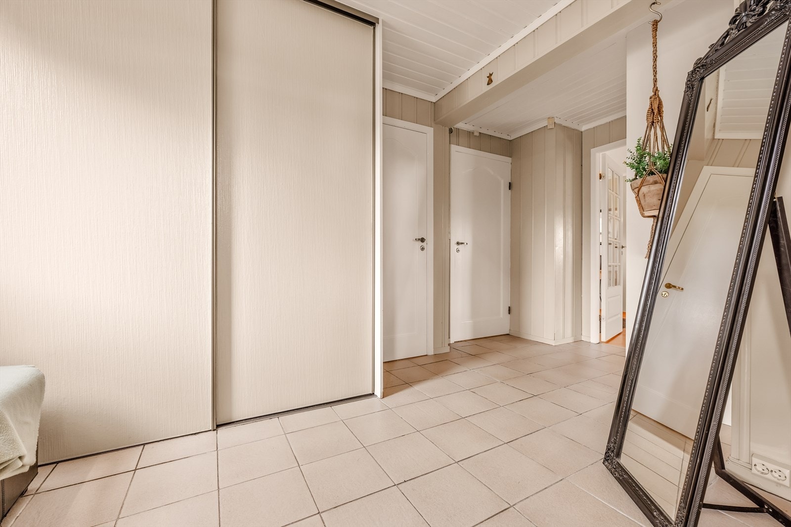Stor flislagt hall med skyvedørsgarderobe, gjeste WC og soverom. God plass for oppbevaring av yttertøy og sko. Galleribilde