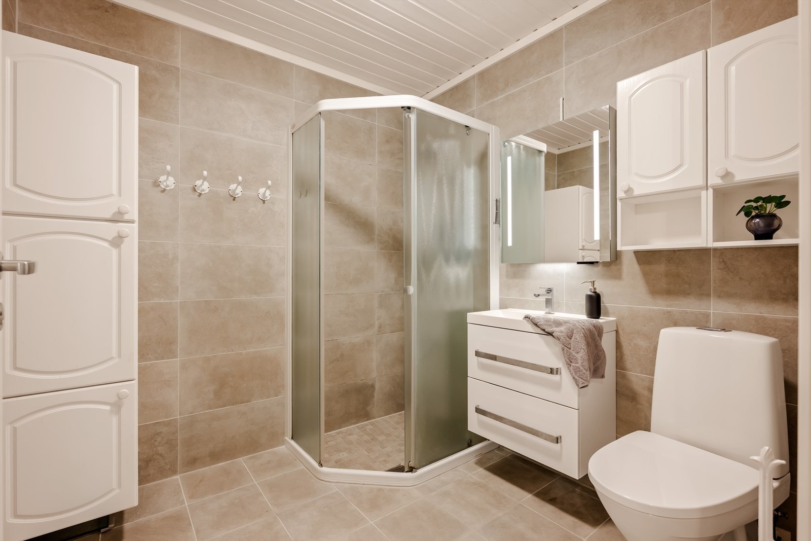 Badet i underetasjen har flislagt gulv med gulvvarme og en praktisk dusjnisje. Pusset opp for ca. 10 år siden. Galleribilde