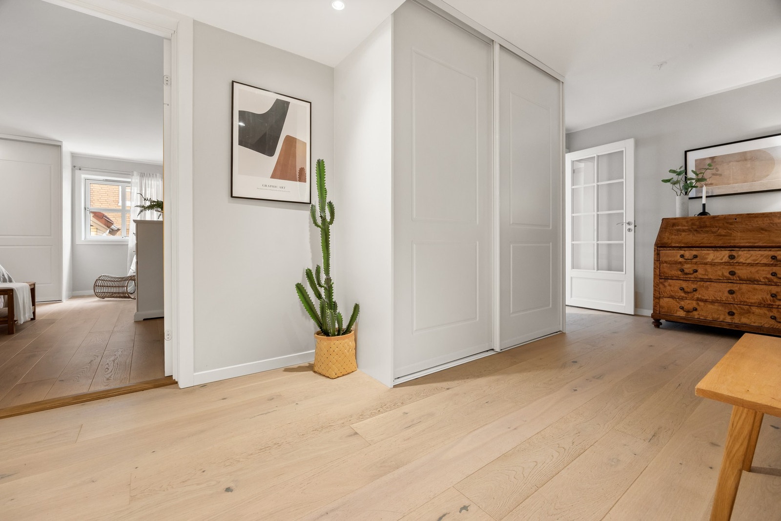 Romslig entré og gang med praktiske skyvedørsgarderober. Galleribilde