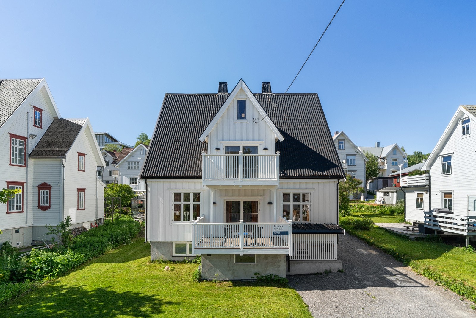 Eiendomstomt med stor hage med plen, enkel garasje og rikelig med oppstillingsplasser for bil i innkjørselen. Galleribilde