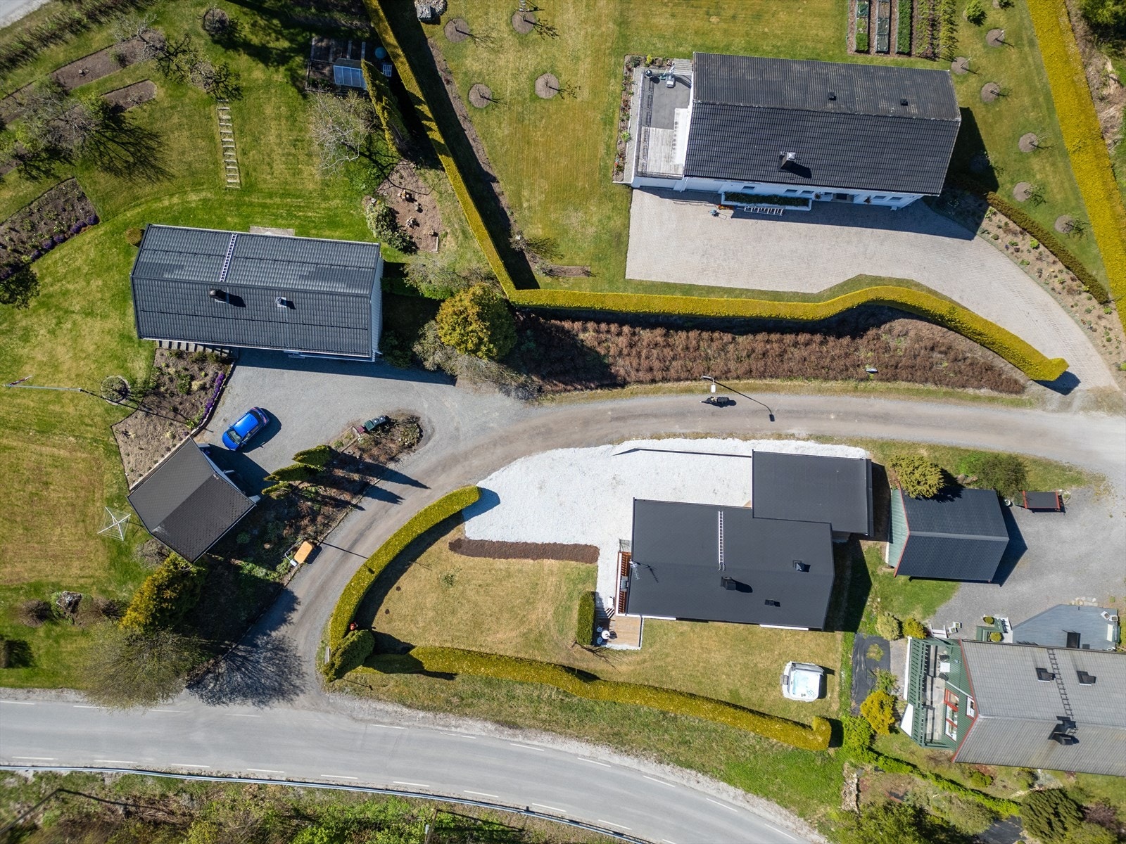 Tomten er beplantet med tett og skjermende hekk, prydbeplantning og blomsterbed. Galleribilde