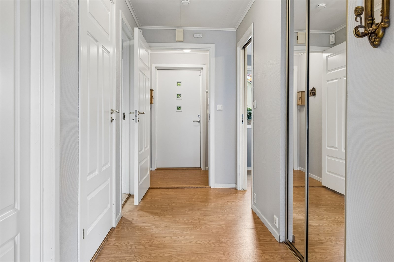 Videre inn ligger en gang med plassbygd skyvedørsgarderobe. Galleribilde