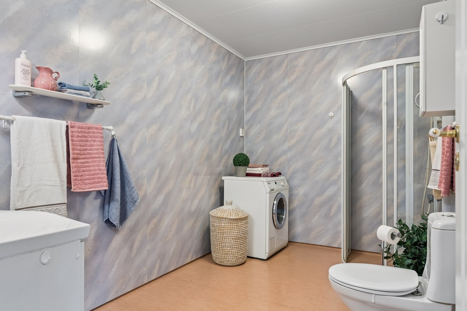 Badet er av god størrelse og har gulvstående toalett og dusjhjørne med skyvedører. I tillegg er det opplegg for vaskemaskin. Galleribilde