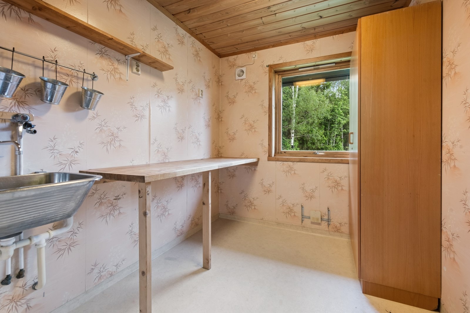 Praktisk vaskerom med benkeplate, opplegg for vaskemaskin og mekanisk avtrekk. Galleribilde