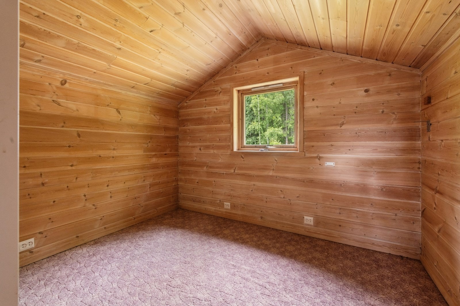 Det andre rommet i loftsetasjen har panel på vegger og tak og er i bruk som en liten loftsstue. Galleribilde
