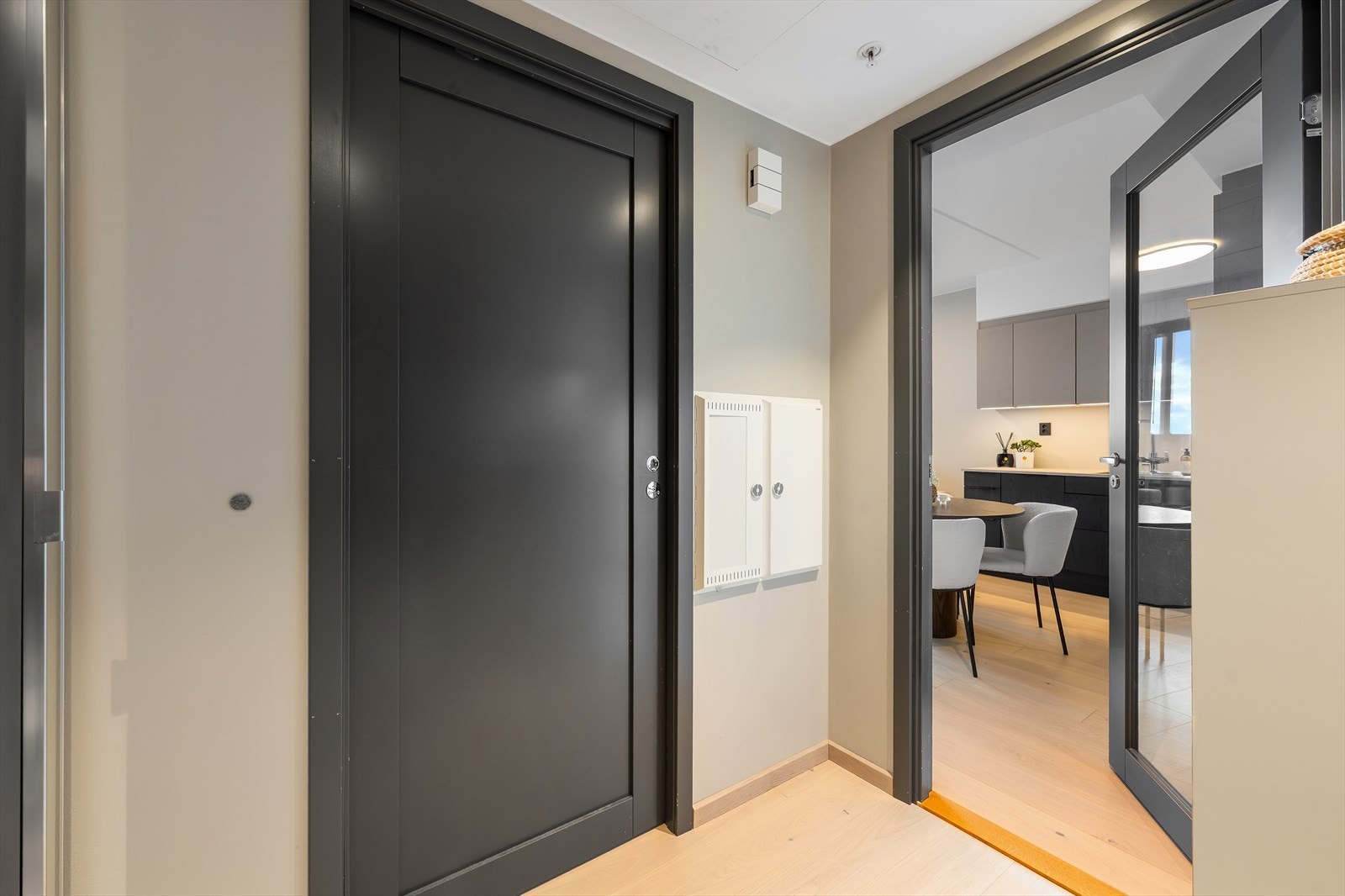 Praktisk og stilren gang/entré med gode oppbevaringsmuligheter og adkomst til boligens øvrige rom. Lyse gulv og mørke dører gir et moderne og ryddig uttrykk. Galleribilde