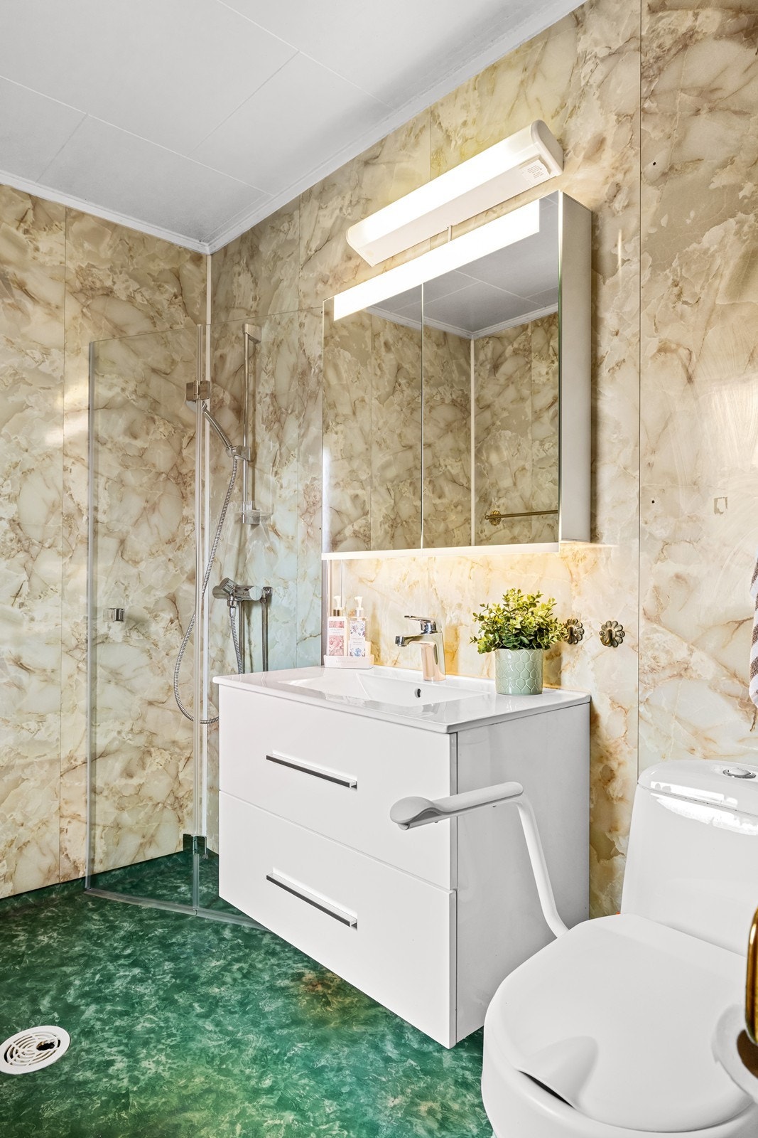 Badet i første etasje har baderomsplater på veggene, dusjhjørne og servantinnredning. Galleribilde