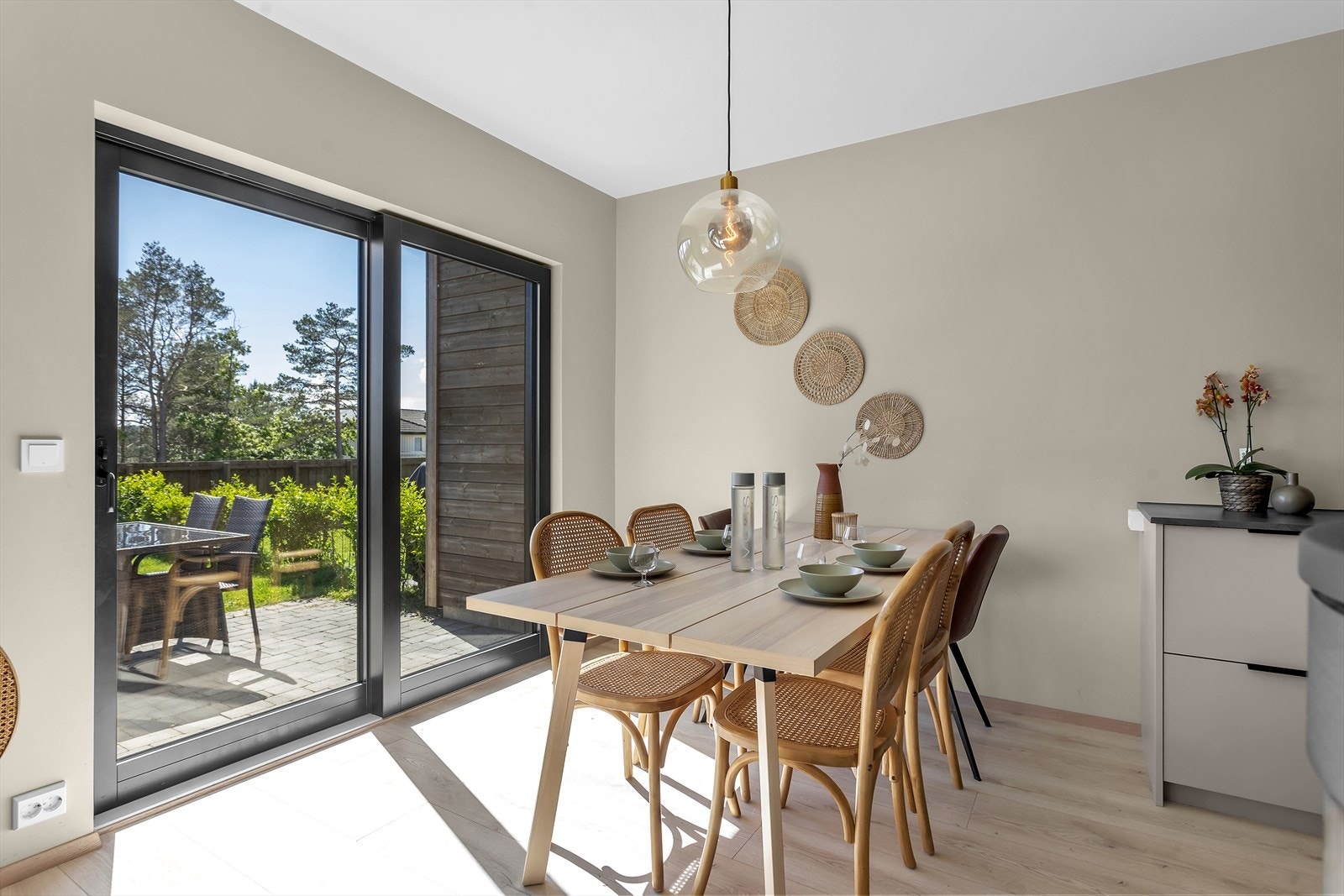 Fra stuen er det utgang til uteområdet og hagen via en solid skyvedør, som effektivt inviterer uteområdet til å bli en naturlig forlengelse av stuen - perfekt for både hverdag og sosiale sammenkomster. Galleribilde