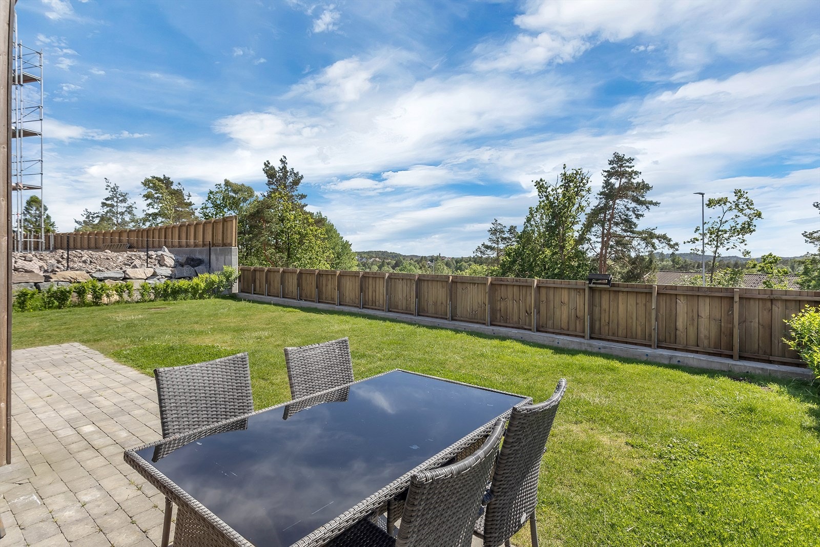 Stort, solrikt og lettstelt uteareal som omkranser boligen, med steinbelagte overflater som gir god plass til utemøbler og grill. Dette uteområdet fungerer som et naturlig og trivelig samlingspunkt på varme sommerdager, perfekt for hyggelige sammenkomster Galleribilde