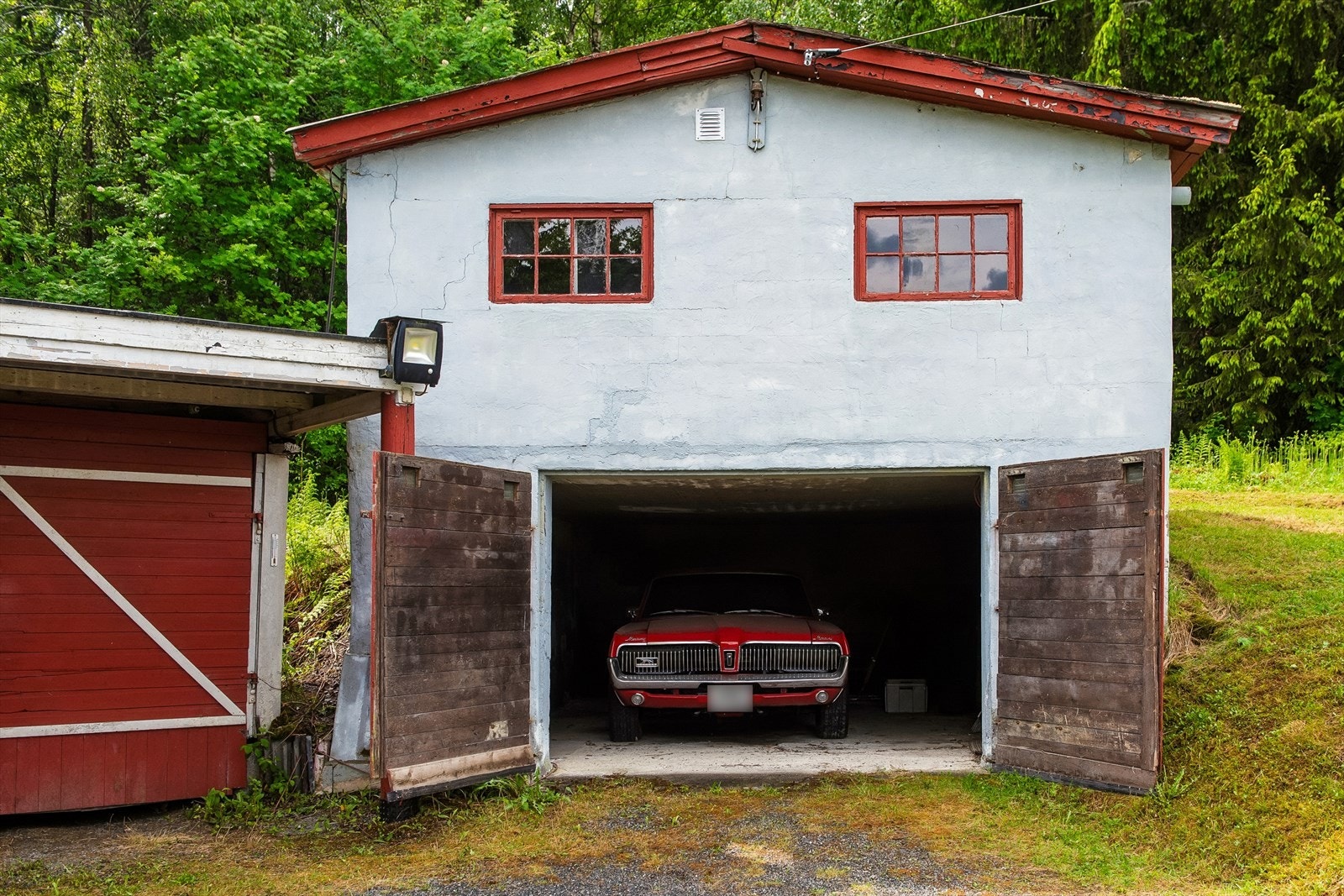 Garasjen fra 1961 har støpt gulv, innlagt strøm og et loft med bodareal. Galleribilde