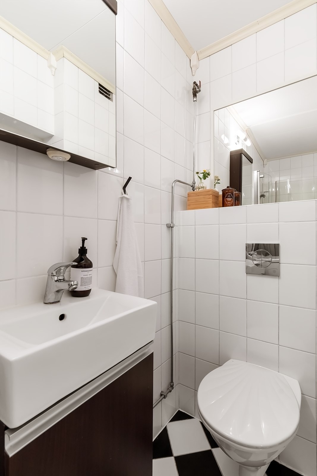 Badet er innredet med nedfelt servant i underskap, speilskap, vegghengt toalett og dusjhjørne med innfellbare glassdører. Galleribilde