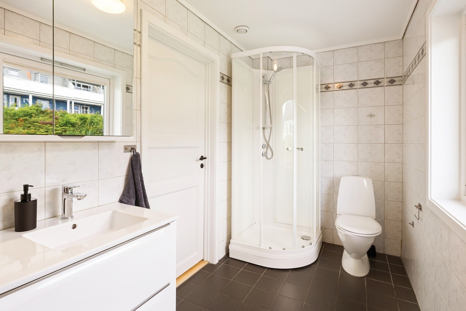 Badet inneholder innredning med servant, toalett, dusjkabinett, badekar, speil og belysning Galleribilde