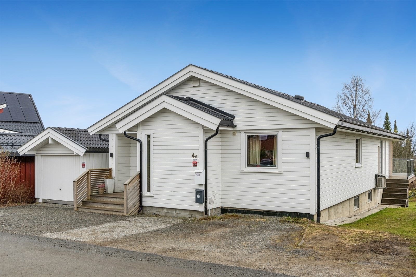 Eiendommen har en gruset gårdsplass med biloppstillingsplasser og en garasje. Galleribilde