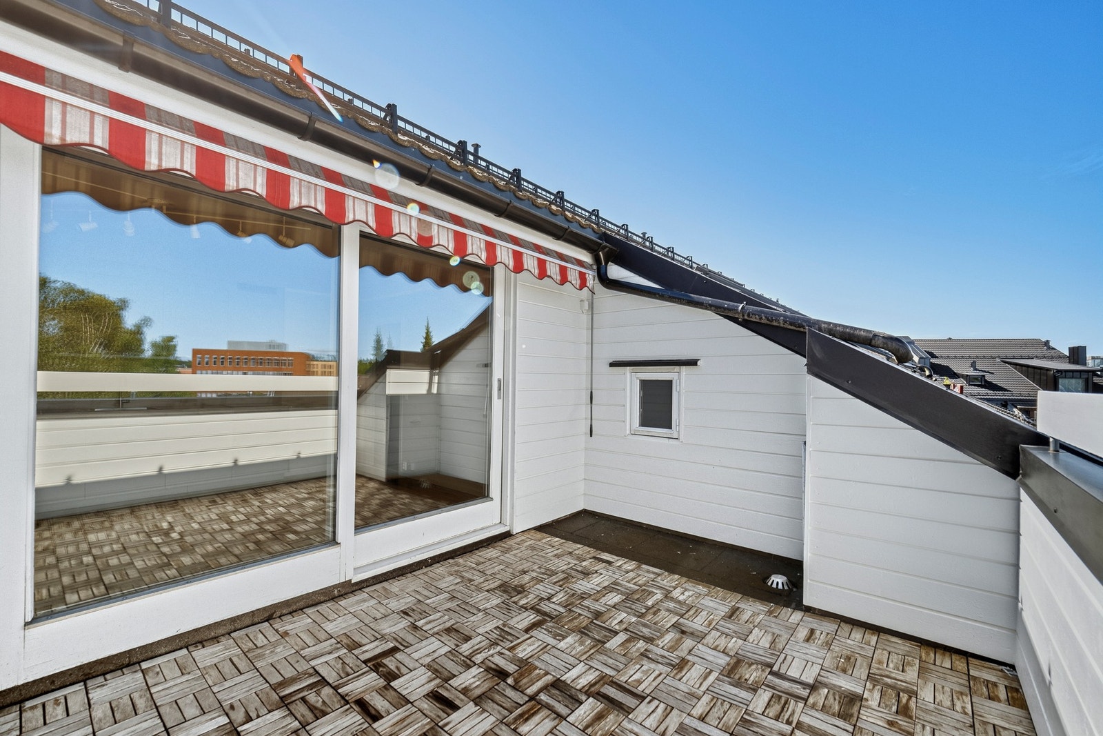 Det er utgang fra stue/kjøkken til en nordvestvendt terrasse på ca. 9 kvm. Galleribilde