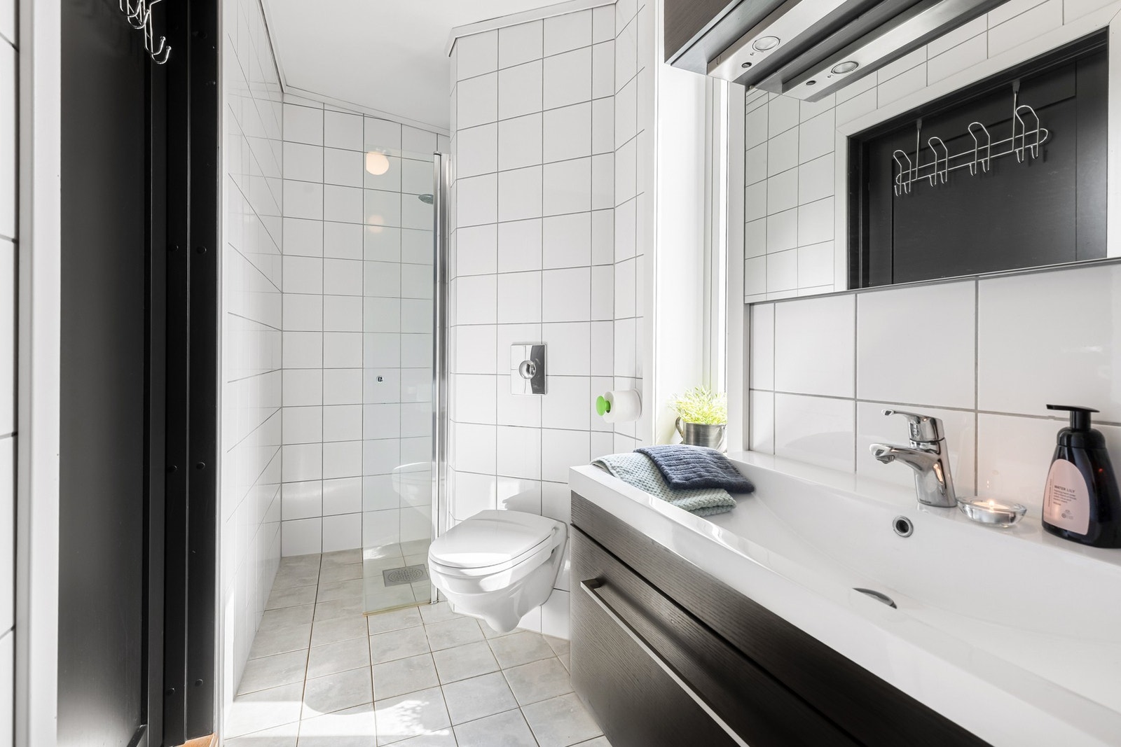 Badet er innredet med dusj, toalett, servant med innredning og opplegg for vaskemaskin. Galleribilde