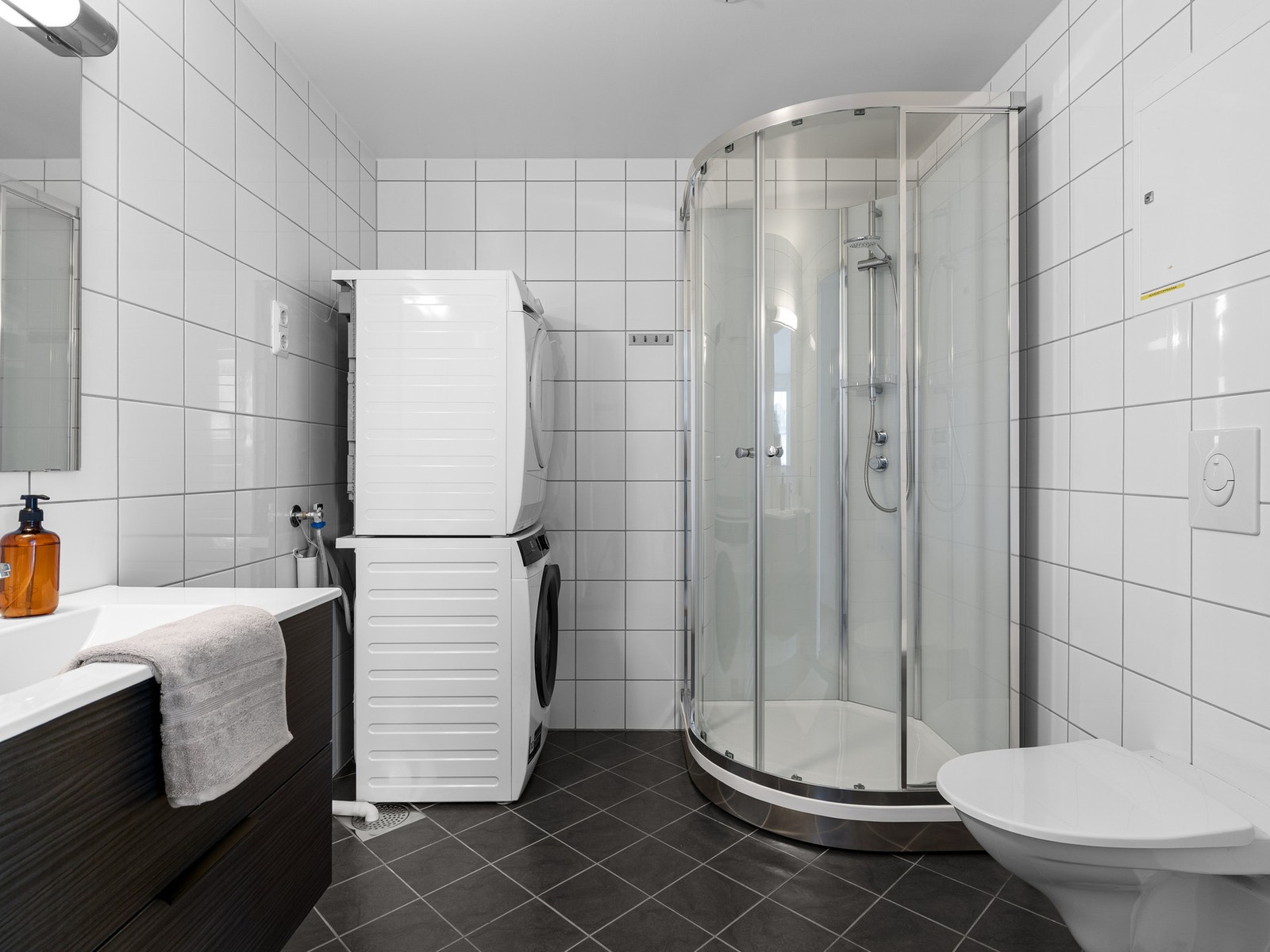 Leilighetens bad har fliser på både gulv og vegger, samt gulvvarme. Badet er innredet med servant på skuffeseksjon og speil. Galleribilde