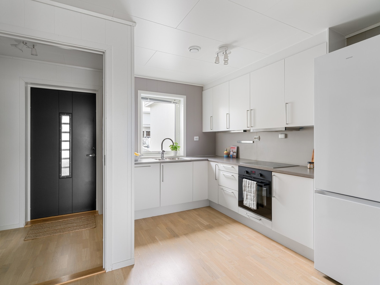 Kjøkkeninnredning med slette fronter og benkeplate i laminat. Galleribilde