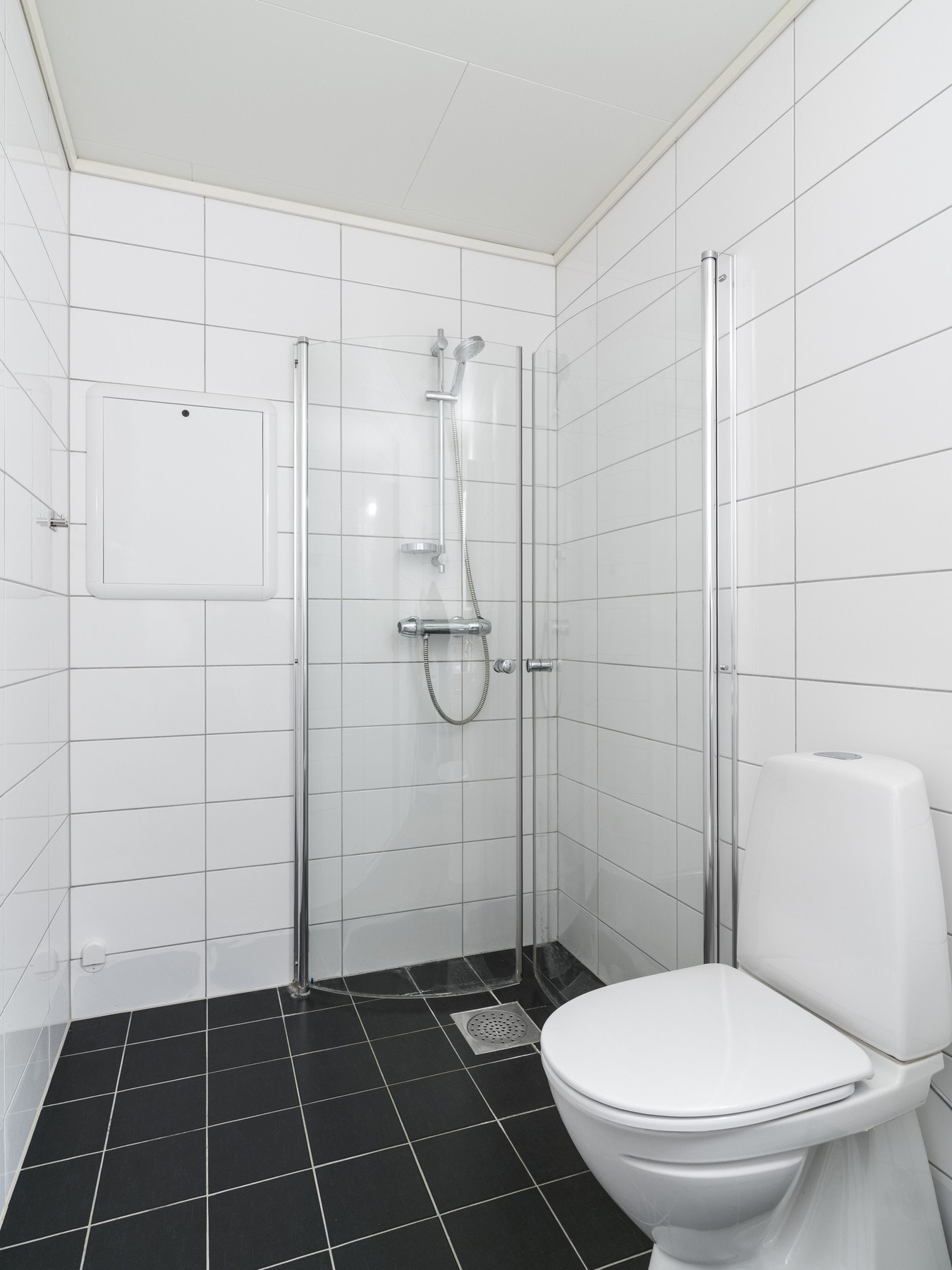 Badet er innredet med servant på skapseksjon og speil. Videre er badet utstyrt med toalett, innfellbare dusjvegger og opplegg for vaskemaskin. Galleribilde