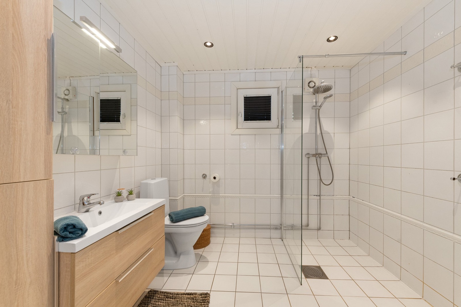 Badet i underetasjen har flislagte overflater med gulvvarme og er innredet med frittstående toalett, vegghengt skapseksjon, speilskap med belysning og dusjnisje med glassvegg. Galleribilde