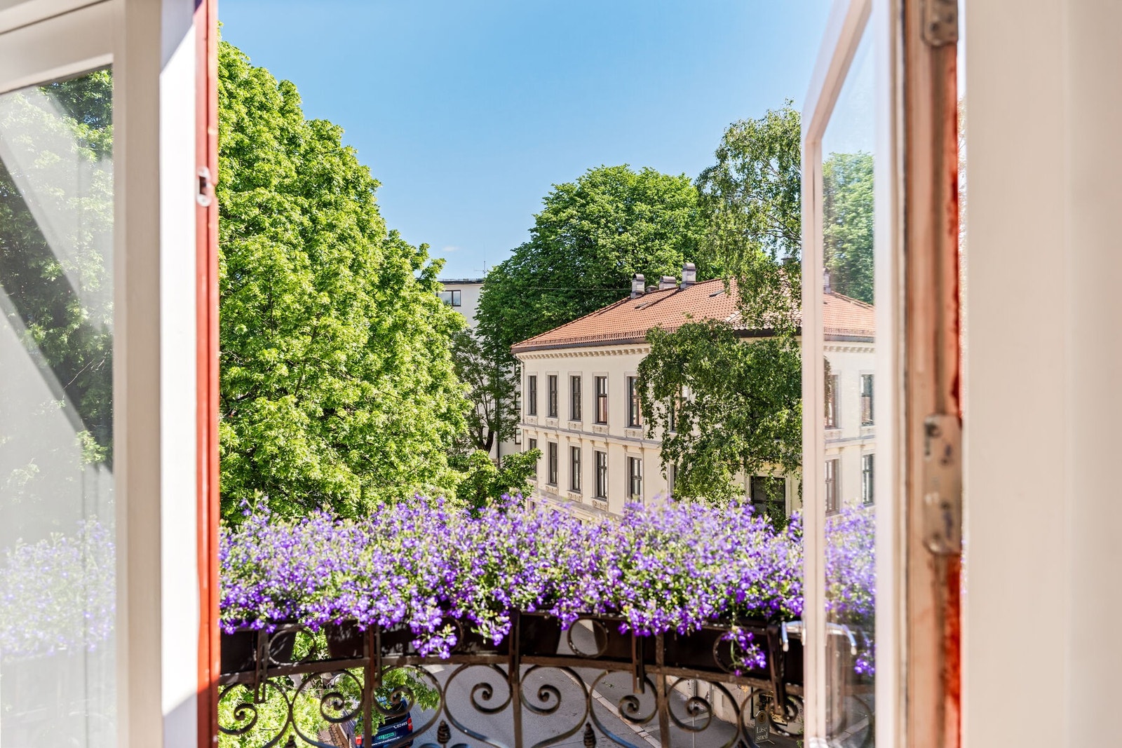 Sol gjennom store deler av dagen og utsikt mot en rolig, grønn bakgård. Galleribilde
