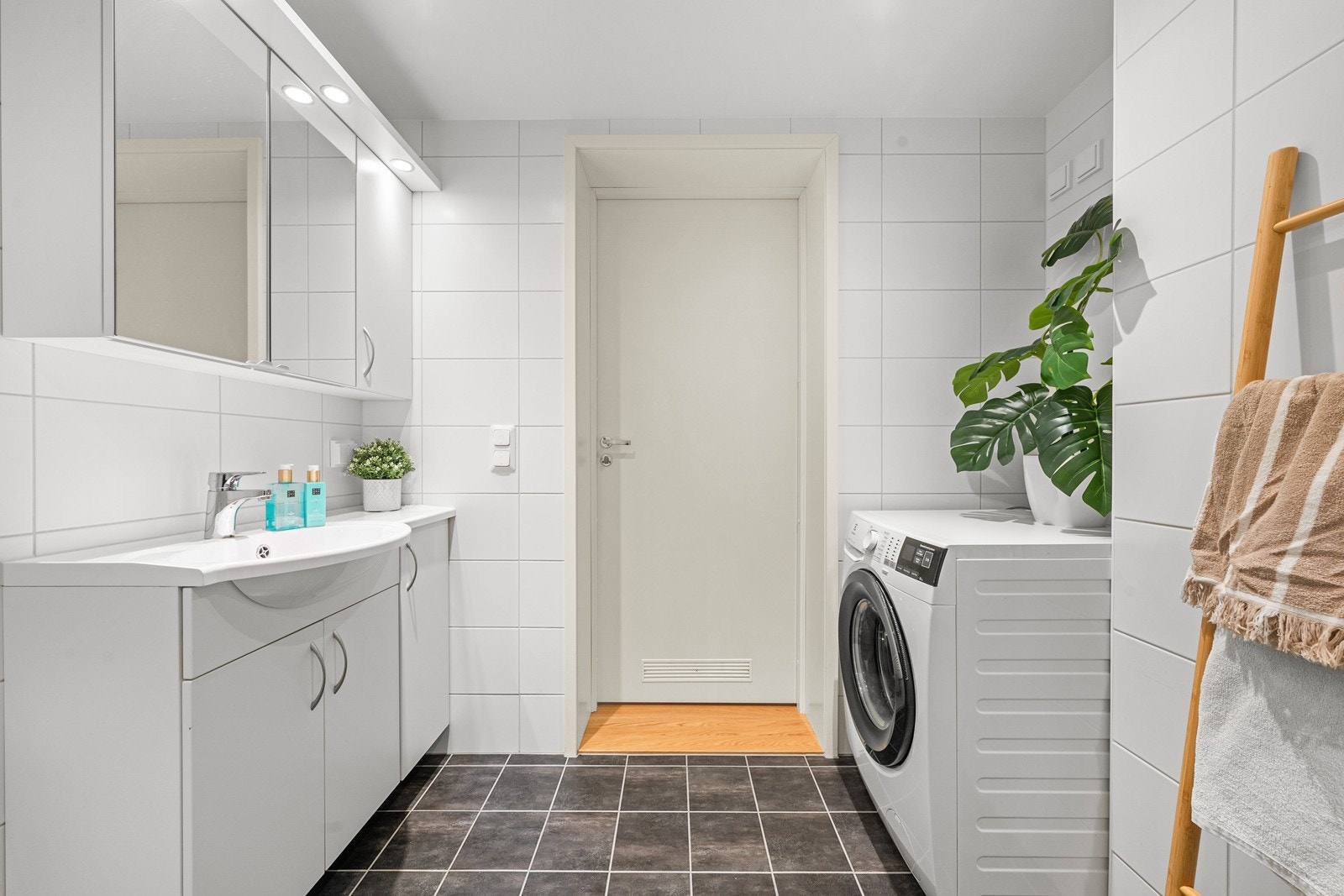 Innredningen består av servant med speilskap, vegghengt toalett og dusjhjørne med glassdører. Det er opplegg for vaskemaskin. Galleribilde