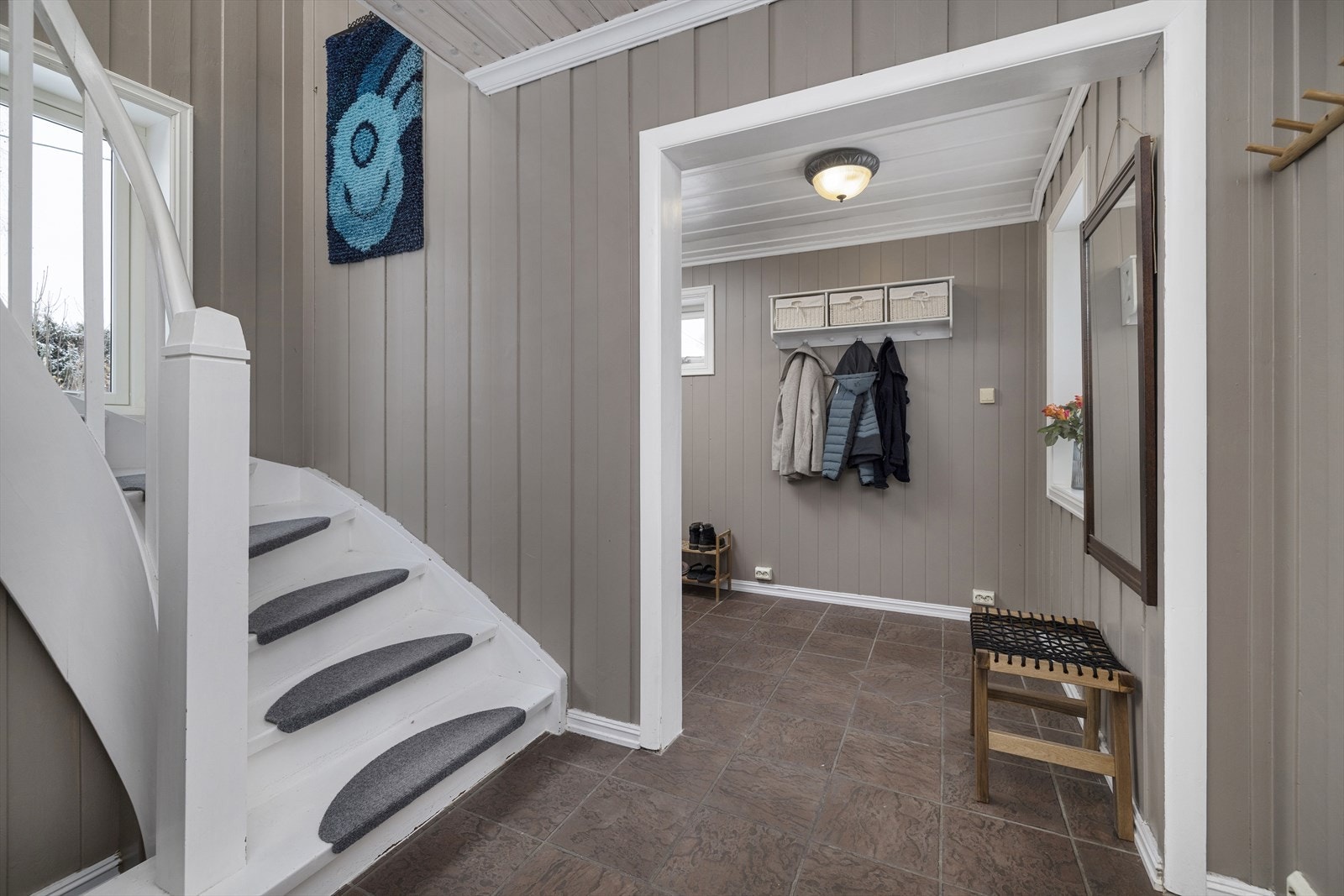 Innbydende gang med panel på vegger og flislagte gulv med varmekabler. Galleribilde