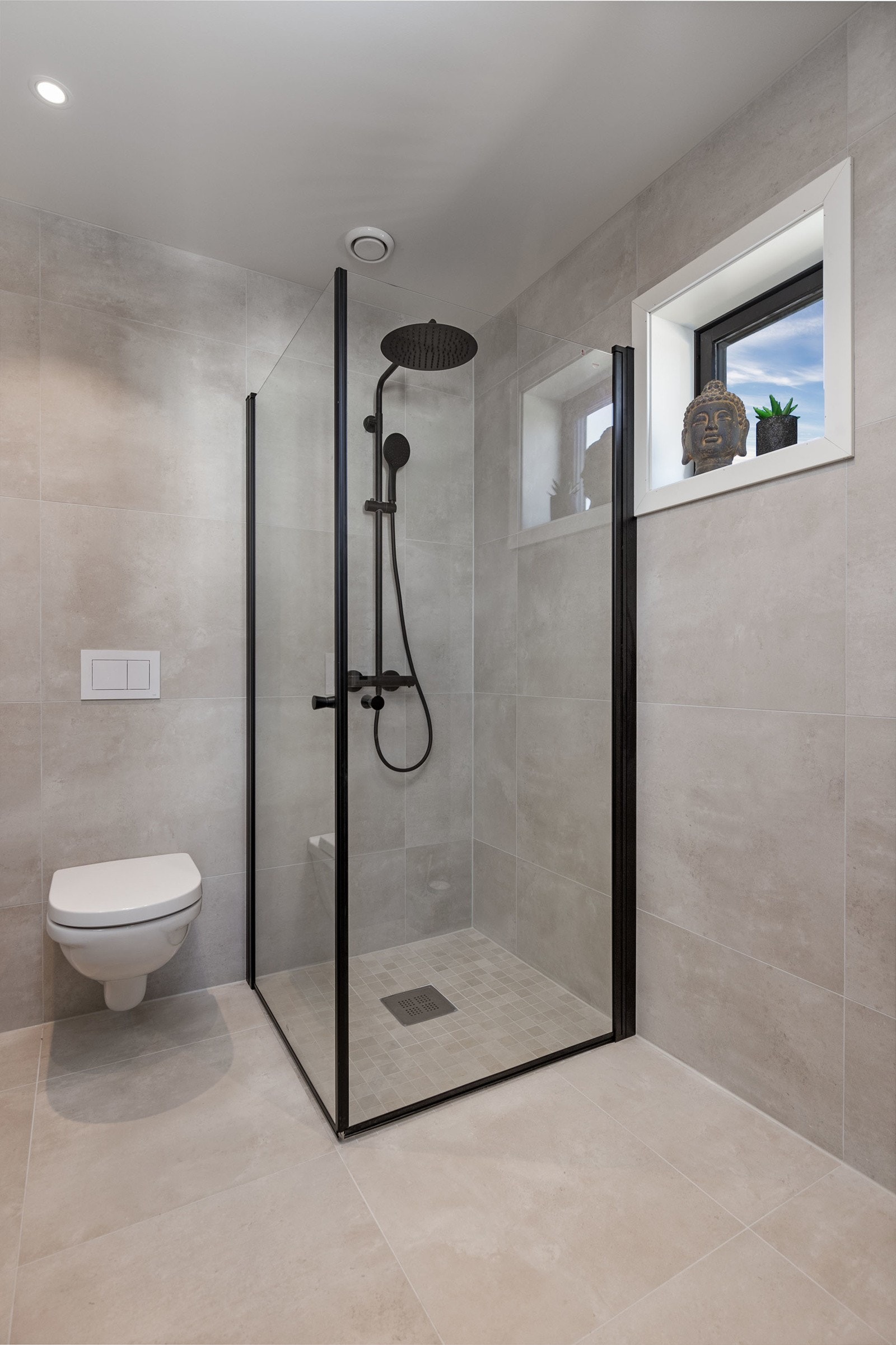 Lekkert bad i tilknytning til hovedsoverom. Delikate fliser av typen Glade Branco Mate Rect 60x60 og Glade Branco Mate 5x5 cm i dusjgulvet. Det er dusjvegger fra Lucca, baderomsinnredning av type Como 90 standard i amerikansk valnøtt Galleribilde