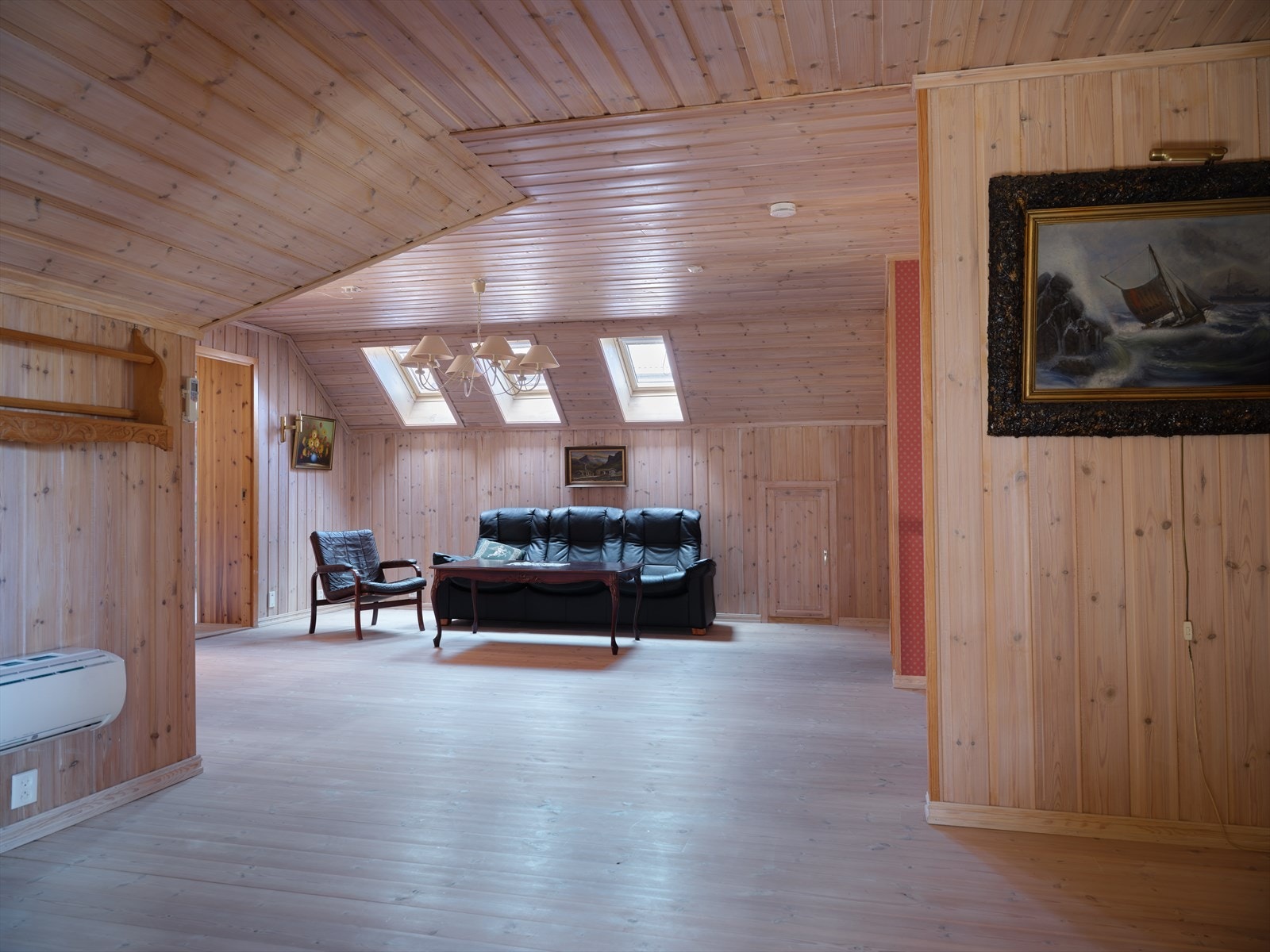 I andre etasje finner du en romslig loftstue med panel på vegger og i tak. Galleribilde