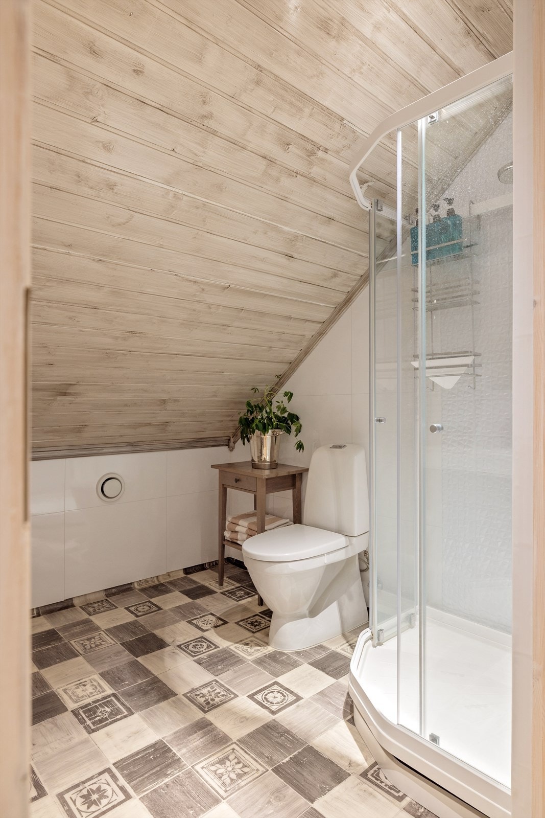 Badet består av baderomsplater på vegger, panel i tak og vinylbelegg på gulv. Galleribilde