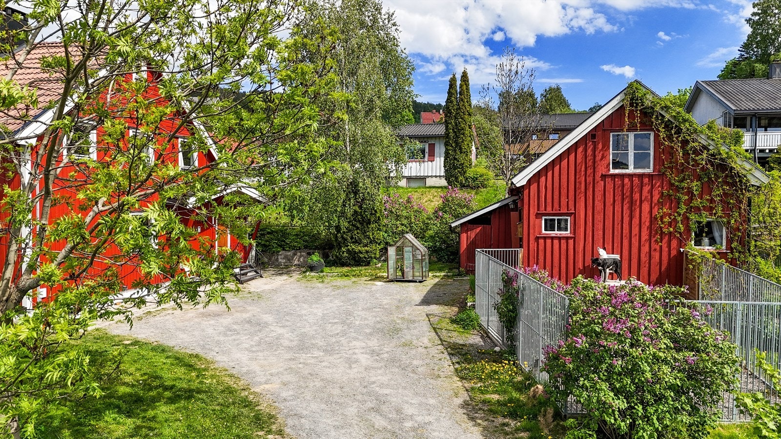 På tomten står et praktisk uthus med garasje og lagringsplass, samt et lite drivhus for den med grønne fingre. Galleribilde