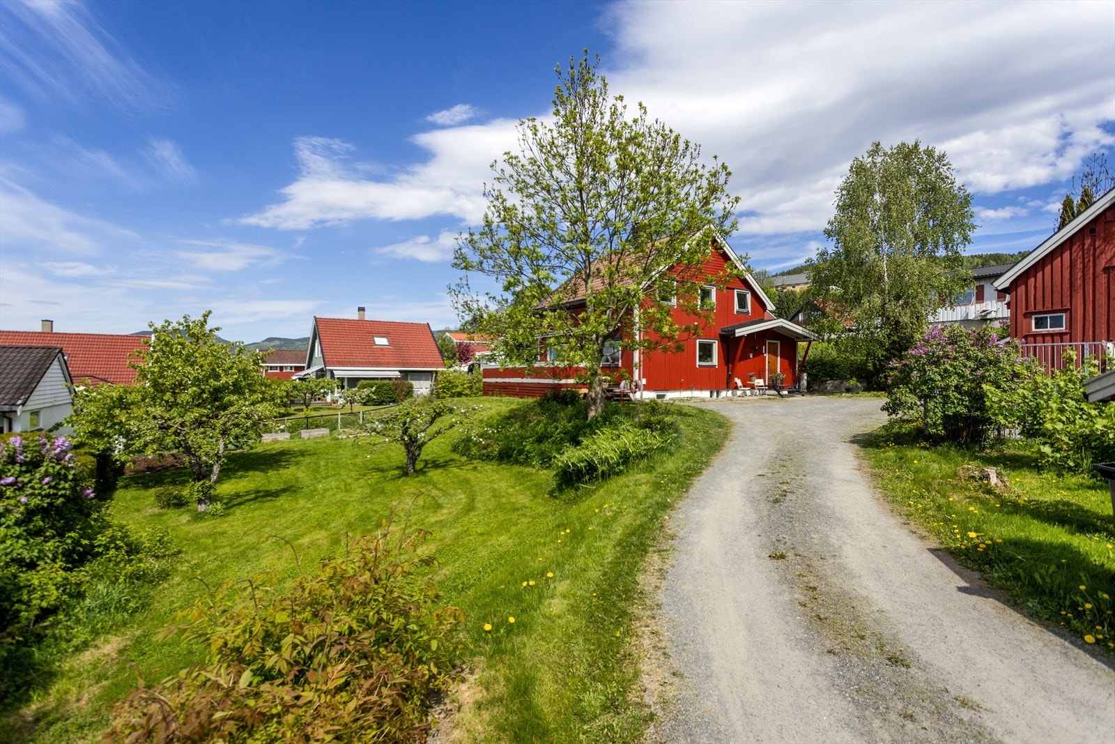 Eiendommen har en stor, opparbeidet hage og gruset innkjørsel med parkering. Galleribilde