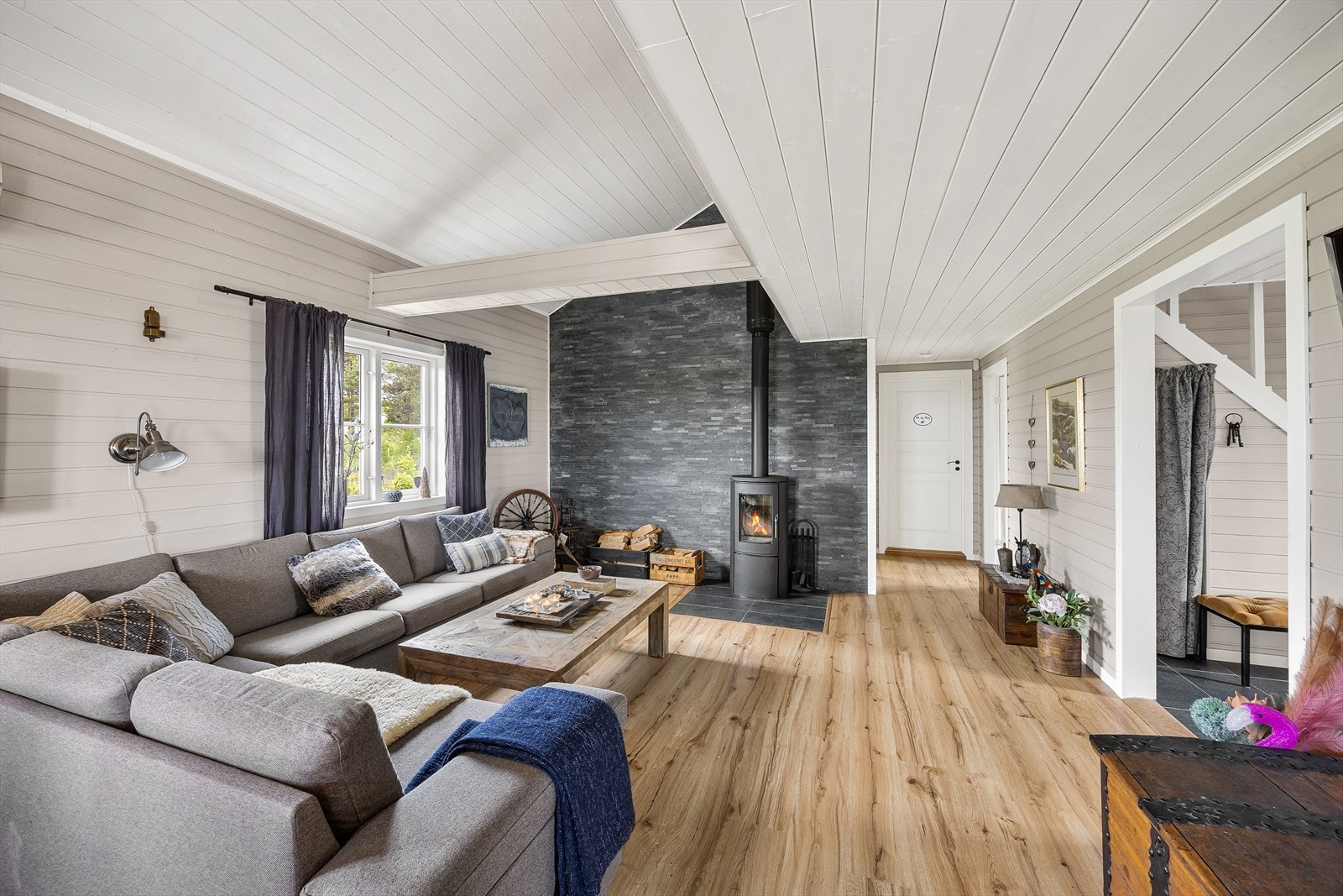 Endeveggen er belagt med skifer og her er det tilkoblet en peisovn for ekstra hygge. Galleribilde