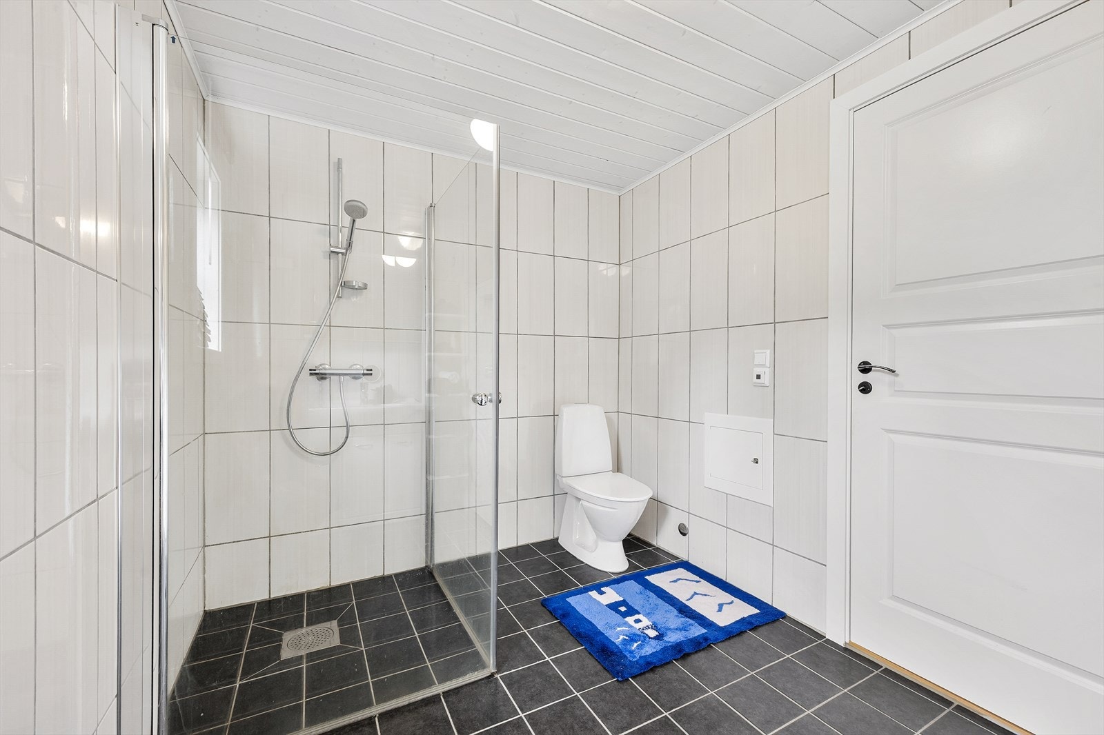 Hovedbadet har også toalett og et dusjhjørne med innfellbare glassdører. Galleribilde