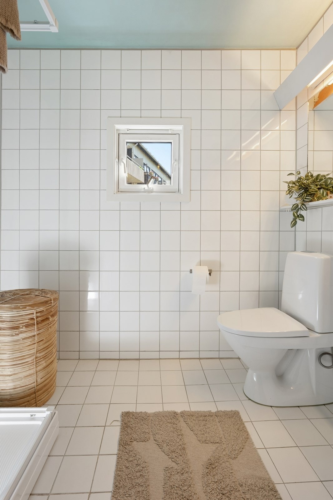 Flislagt bad/vaskerom fra byggeår med funksjonell, todelt løsning. Utstyrt med WC, dusjkabinett, servant med togreps blandebatteri samt eget rom med opplegg for vaskemaskin. Galleribilde