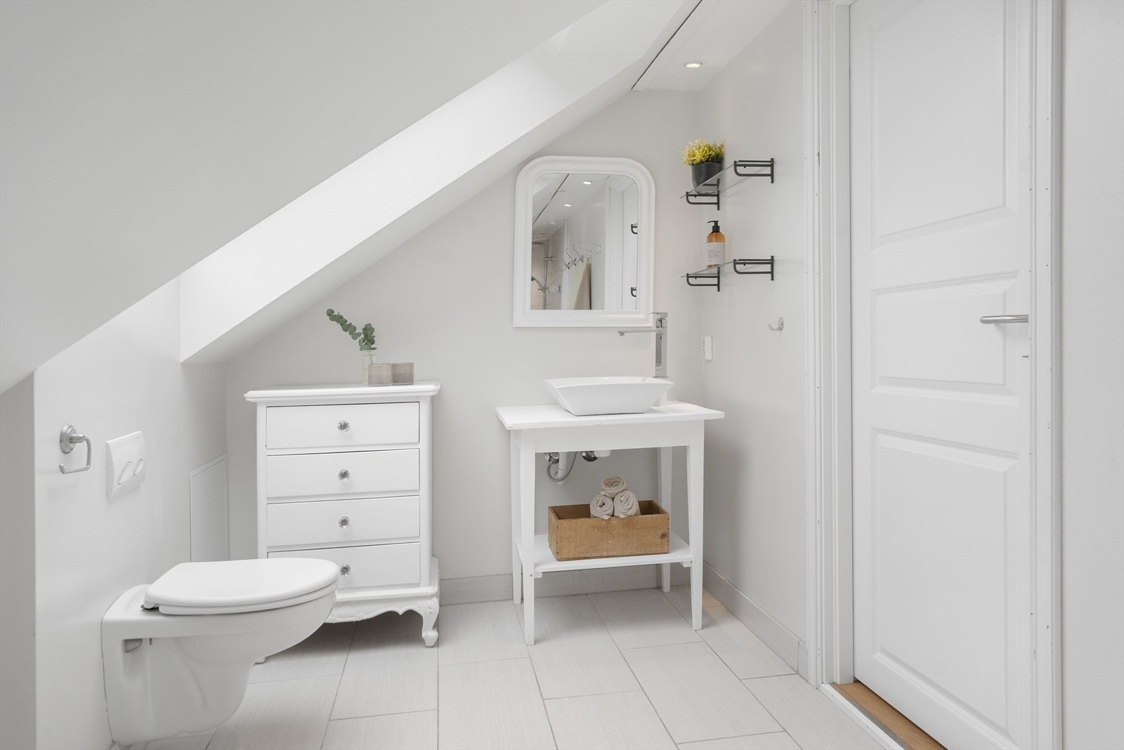 På badet har en dusjhjørne med glassdør, vegghengt toalett og passende baderomsinnredning til eneboligen. Galleribilde