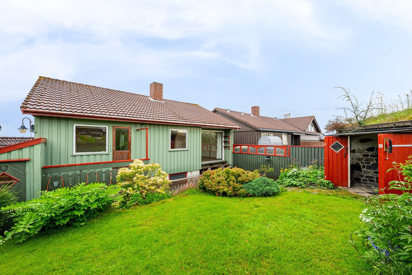 Eiendommen har en pent opparbeidet tomt med plen, bed og flere uteplasser. Galleribilde