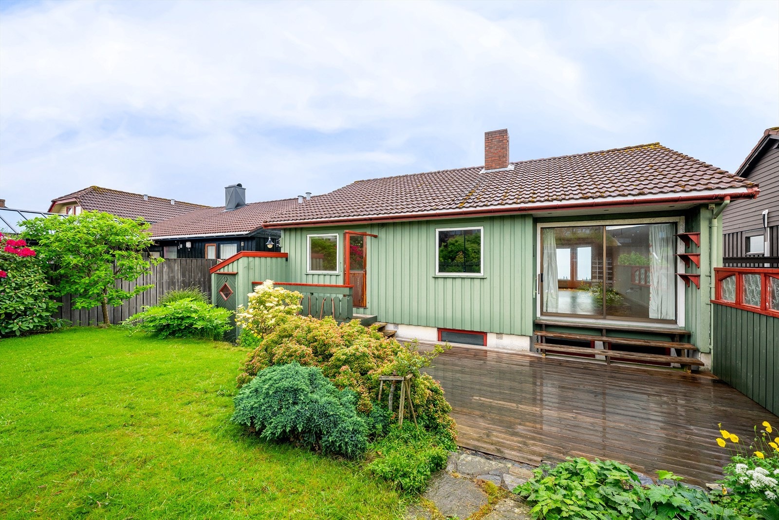 Fra stuen er det utgang til en terrasse og den pent opparbeidede hagen. Galleribilde