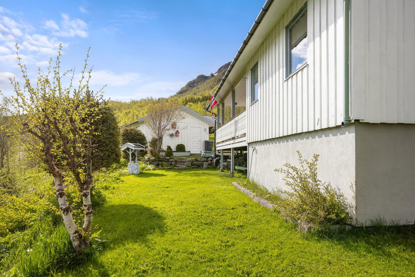 Tomten er opparbeidet med plenarealer og diverse beplantning. Galleribilde