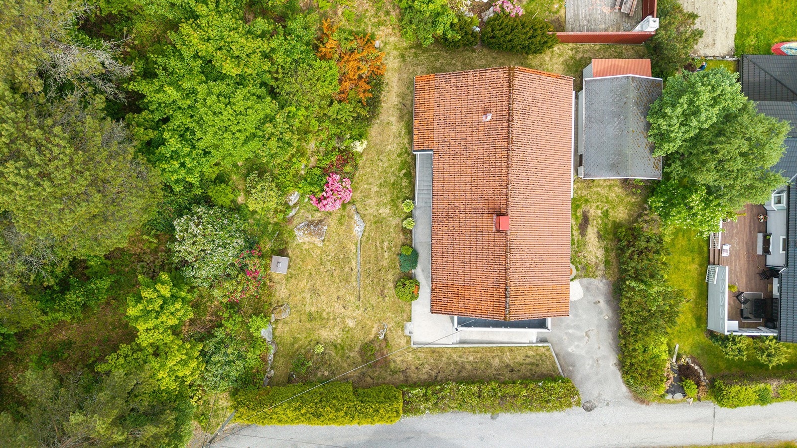 Boligen sett fra luften, med en oversikt over tomten og taket belagt med takstein. Galleribilde