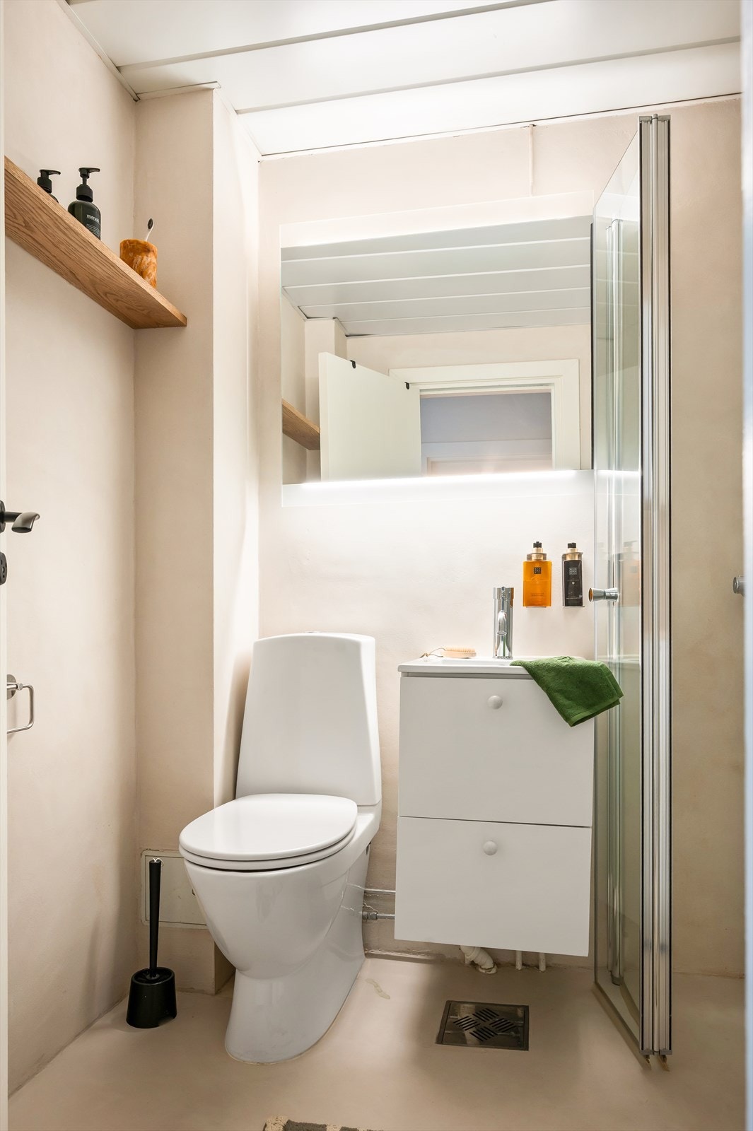 Badet er innredet med toalett, servant i innredning og et dusjhjørne med svingbare glassdører. Opplegg for vaskemaskin. Galleribilde